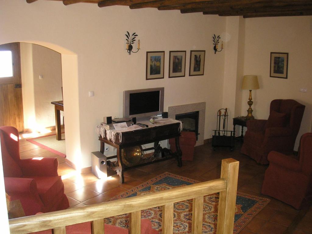 马尔旺卡萨达希尔维尼亚酒店的一间带电视和壁炉的客厅