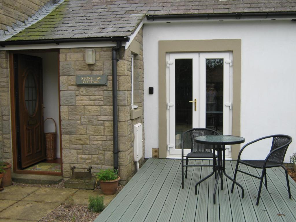 LongframlingtonStoneLaw Cottage的露台配有两把椅子和一张桌子