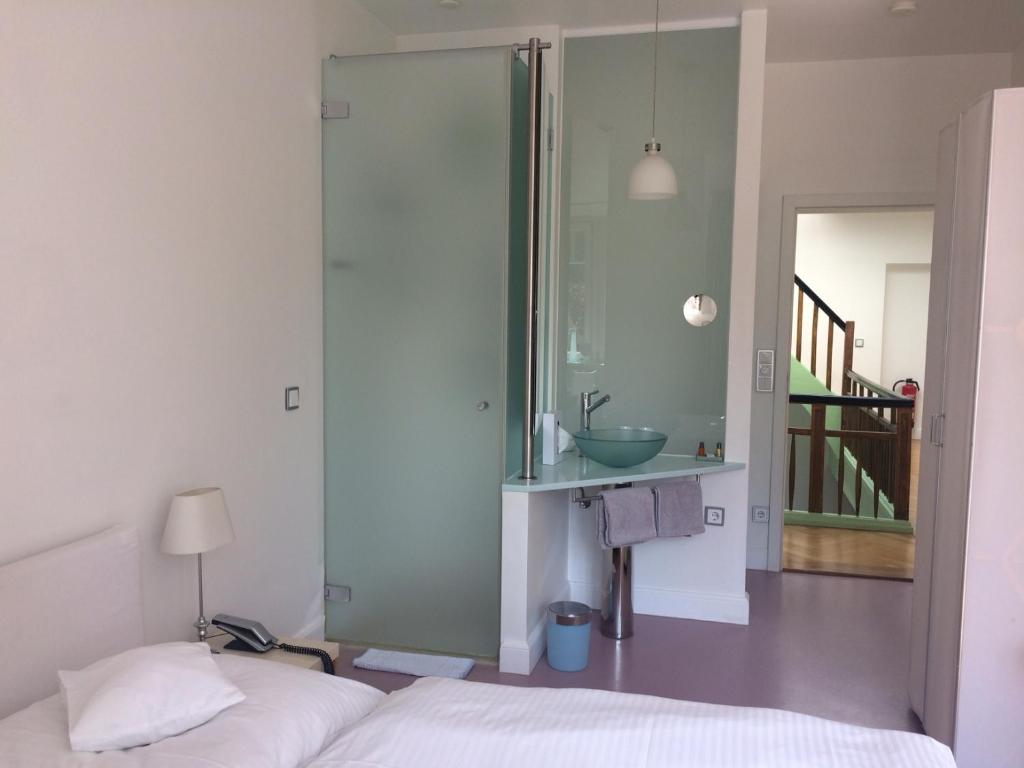 海德堡海德堡阿斯托利亚酒店的一间卧室,配有带水槽的浴室和一张床