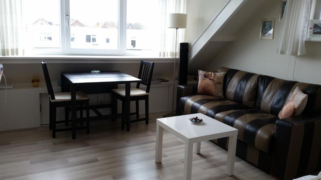 登堡Homestay Texel的客厅配有沙发和桌子