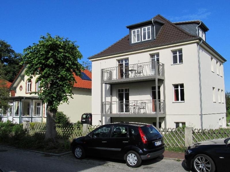 格拉尔-米里茨“Haus am Küstenwald” Ferienwohnungen的一辆停在白色房子前面的黑色汽车