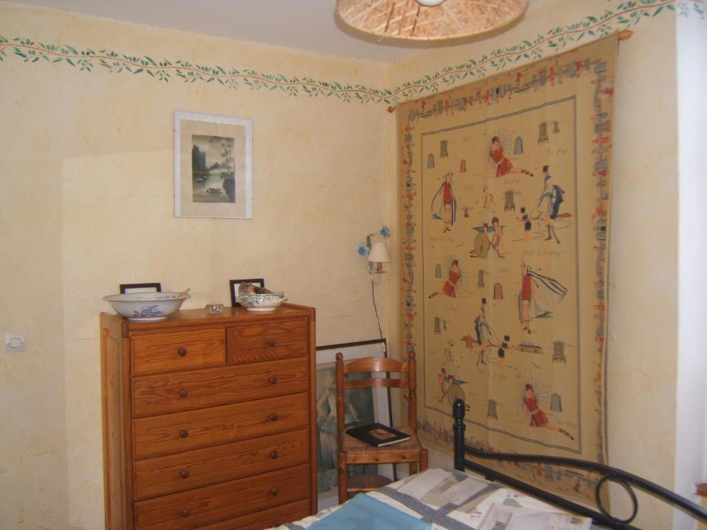 滨海圣奥班Relais du Cap romain的卧室配有梳妆台,墙上挂有绘画作品