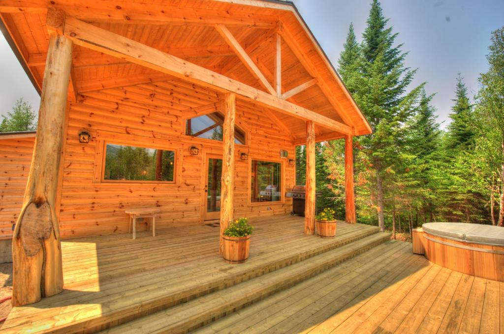 拉马巴耶Le St Bernard - Les Chalets Spa Canada的小木屋设有大型木制甲板