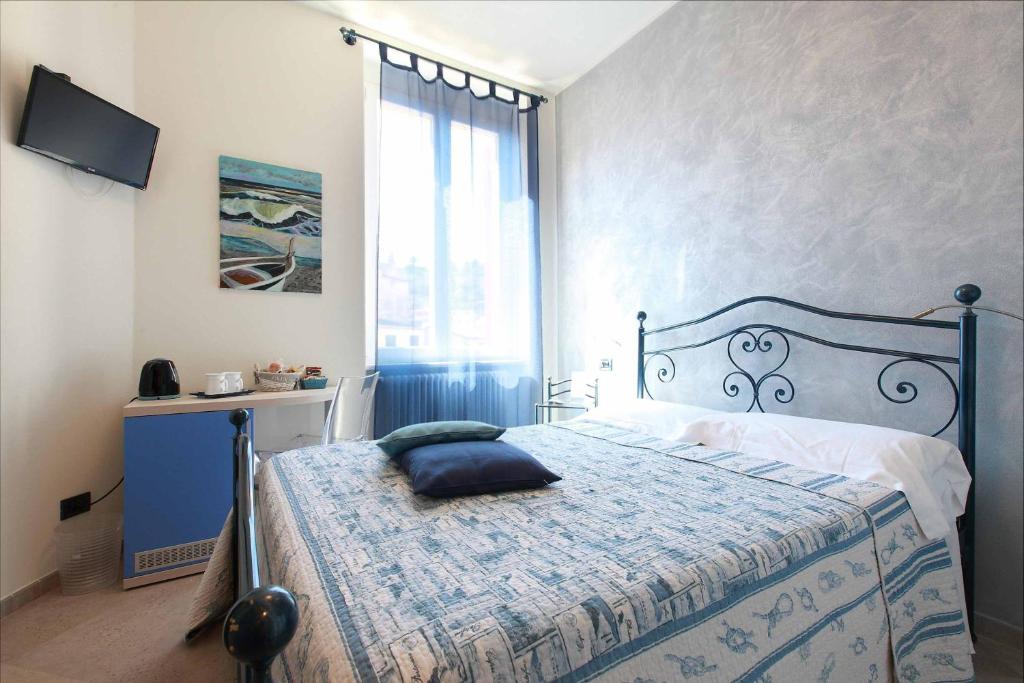蒙特罗索阿尔马雷洛萨德温蒂酒店的一间卧室配有一张带蓝色床罩的床和窗户。