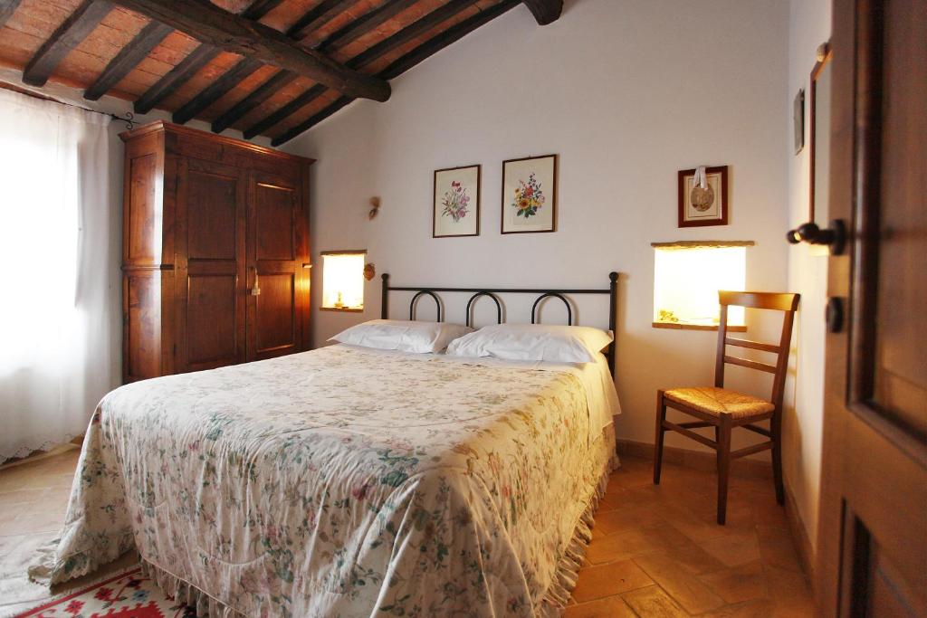 曼恰诺Casale Giacomini的一间卧室配有一张大床和一把椅子