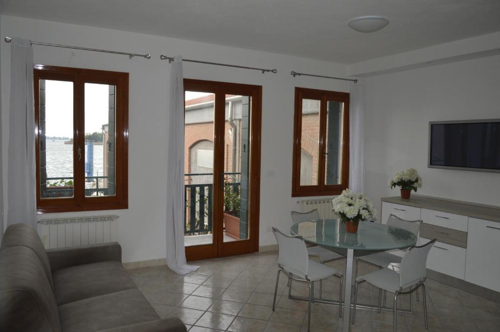 威尼斯Calle Michelangelo Apartments的客厅配有玻璃桌和椅子