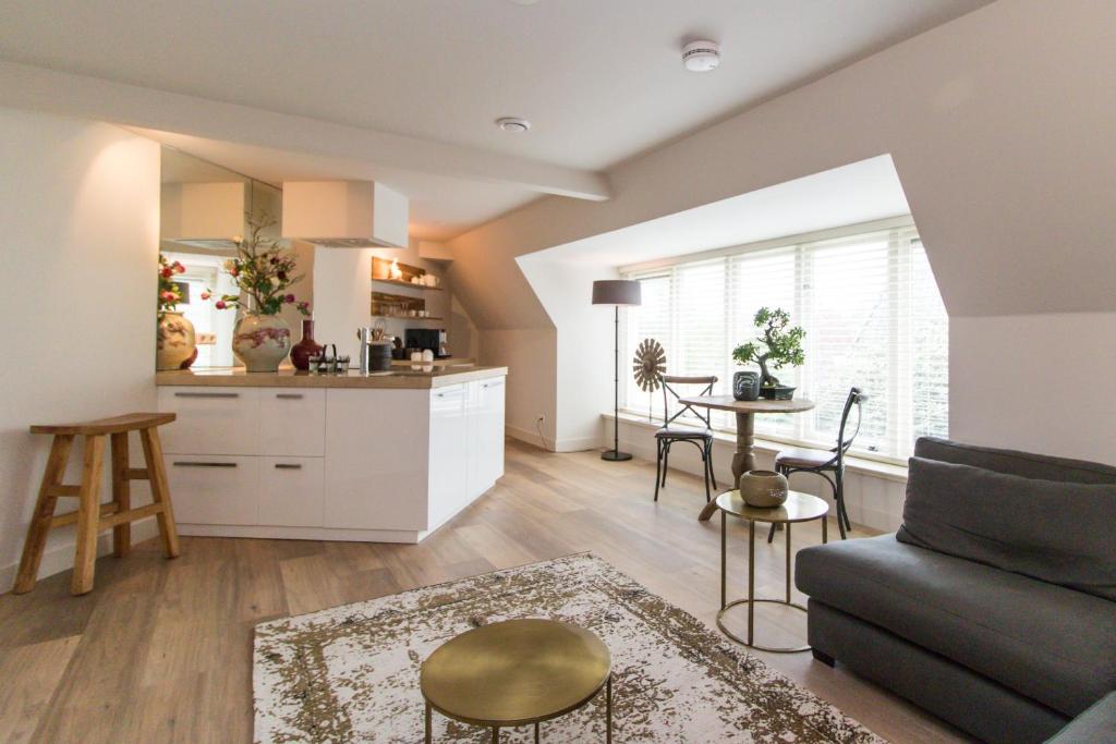 BeilenShort stay Midden Drenthe的厨房以及带沙发和桌子的客厅。