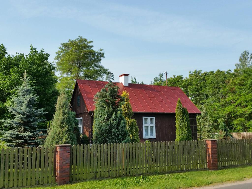 Nowa WolaDomek Drewniany的围栏后面有红色屋顶的房子
