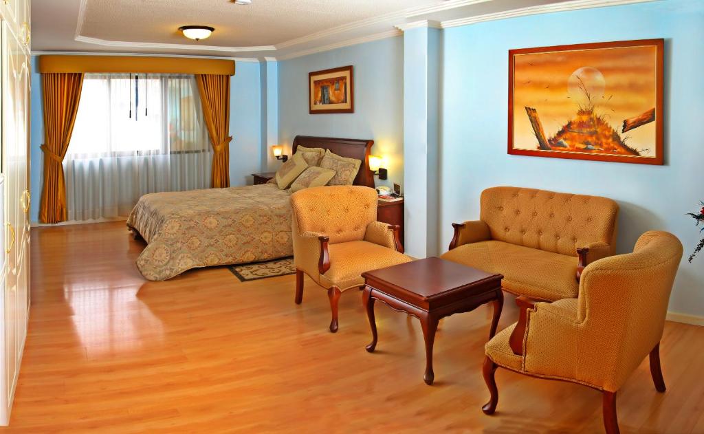 昆卡亚努凯伊酒店的一间卧室配有一张床、两把椅子和一张桌子