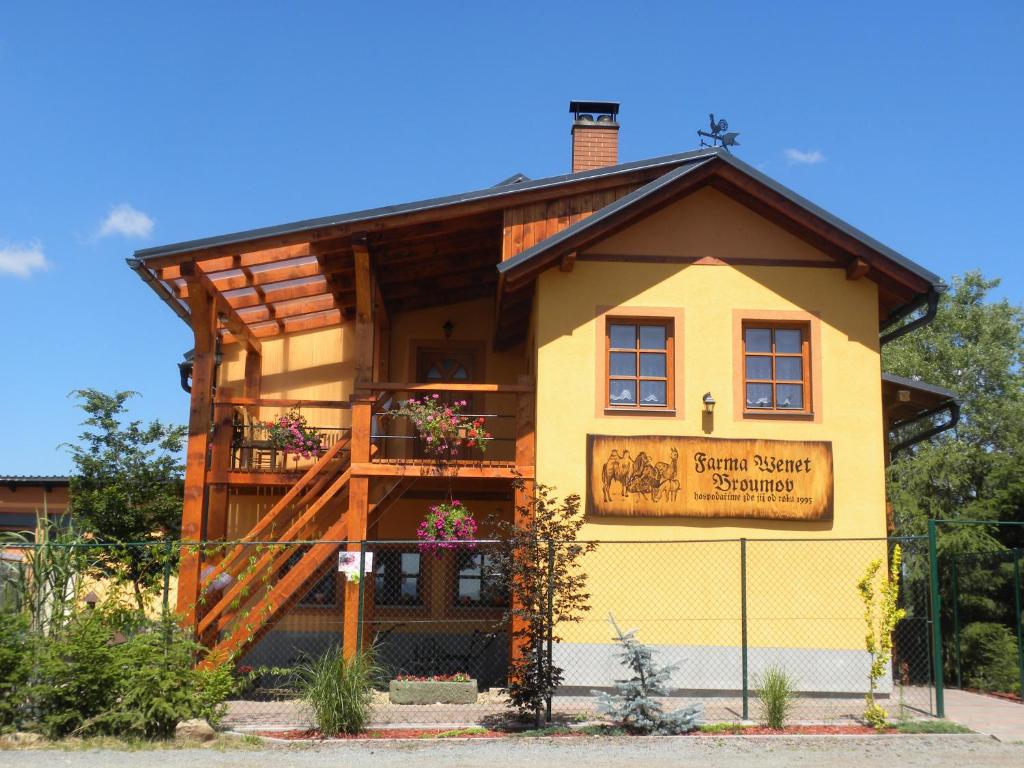 布劳莫夫Farma Wenet的一座黄色的小建筑,上面有标志