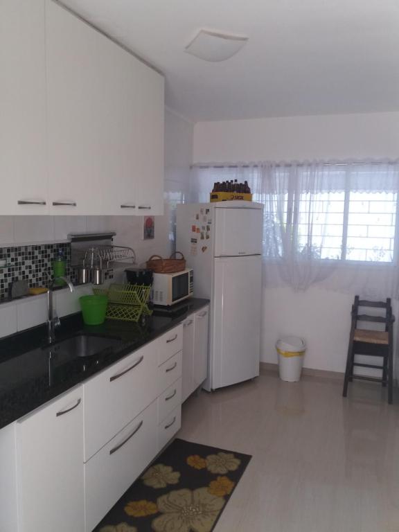 库里提巴Casa com garagem em condomínio的厨房配有白色家电和白色冰箱