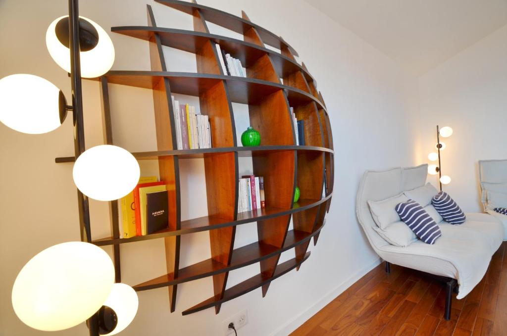 滨海自由城Villefranche Sur Mer One Bed的一间设有书架和白色椅子的房间