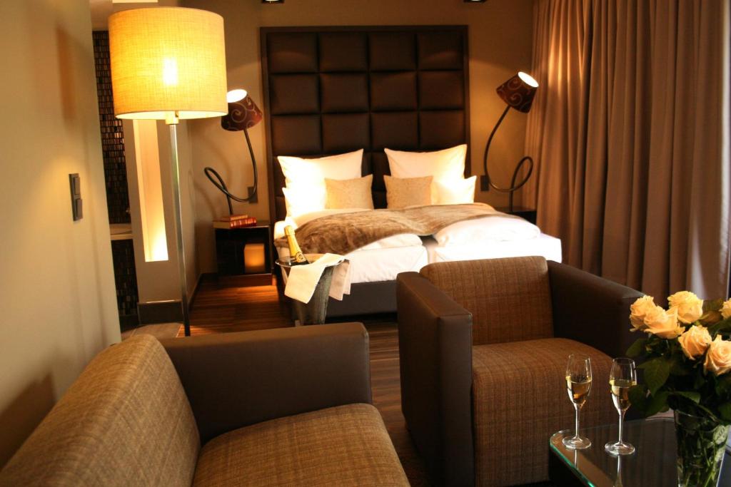 门兴格拉德巴赫罗森米尔酒店的酒店客房,配有一张床和两把椅子