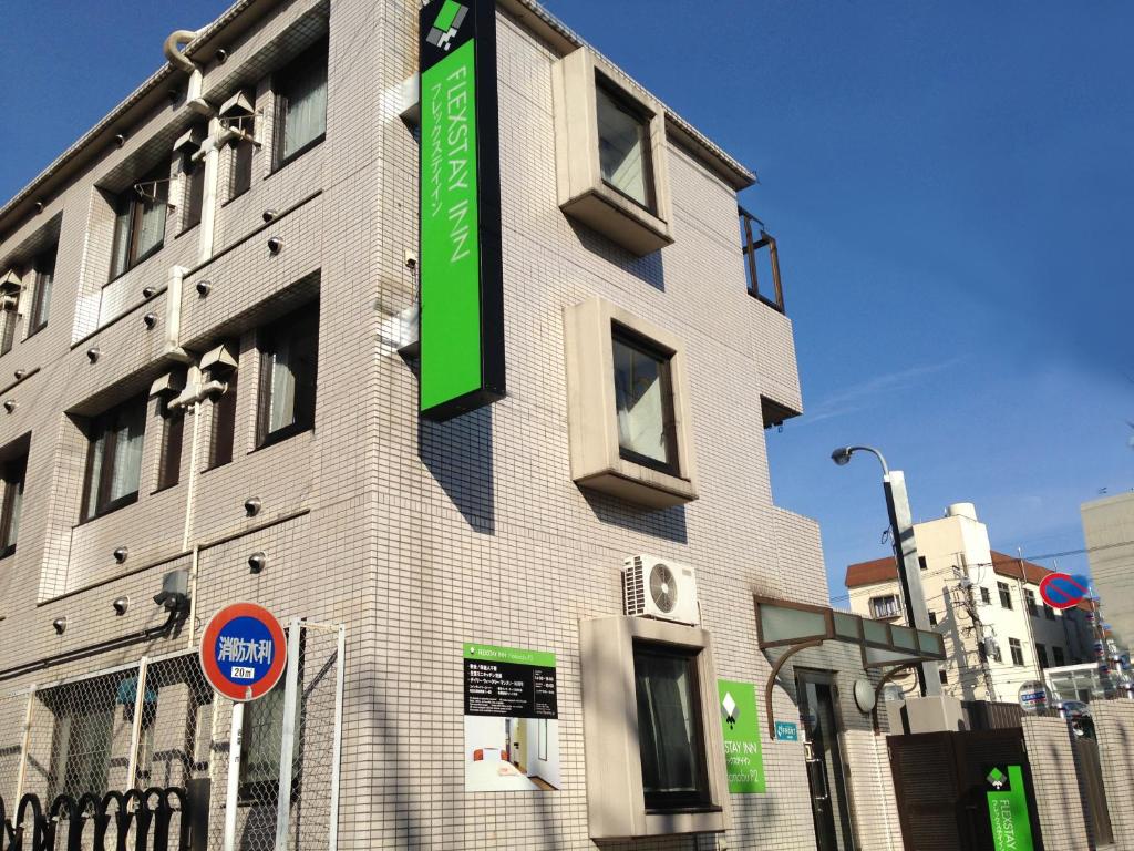 东京FLEXSTAY 中延旅馆的建筑的一侧有绿色标志