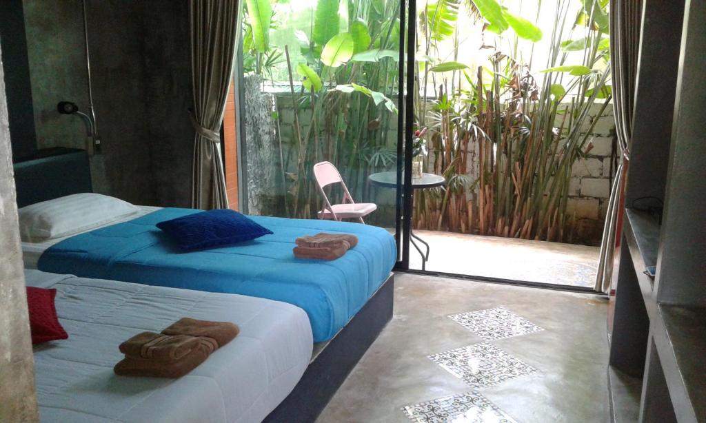 甲米镇班比达旅馆的一间卧室配有一张蓝色床单和一个阳台。