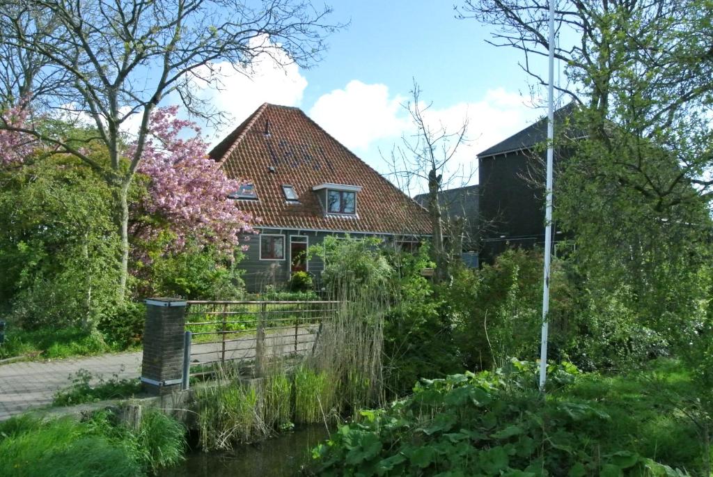 阿姆斯特丹Appartement Voorhuis en chalet Klein Waterland的河中的房子