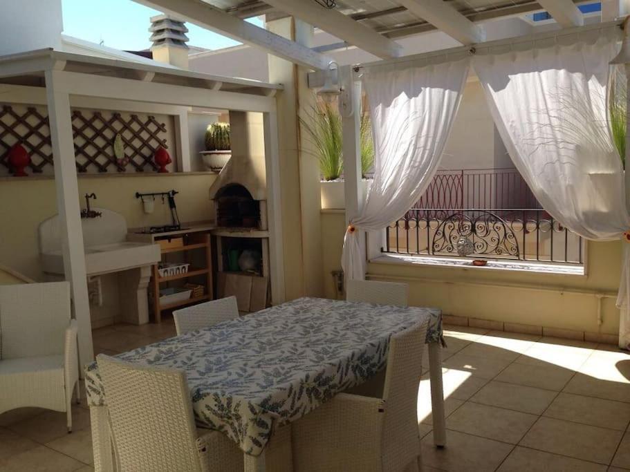 滨海波利尼亚诺Casa Sirena, Locazione Turistica的带阳台的客房内的桌椅