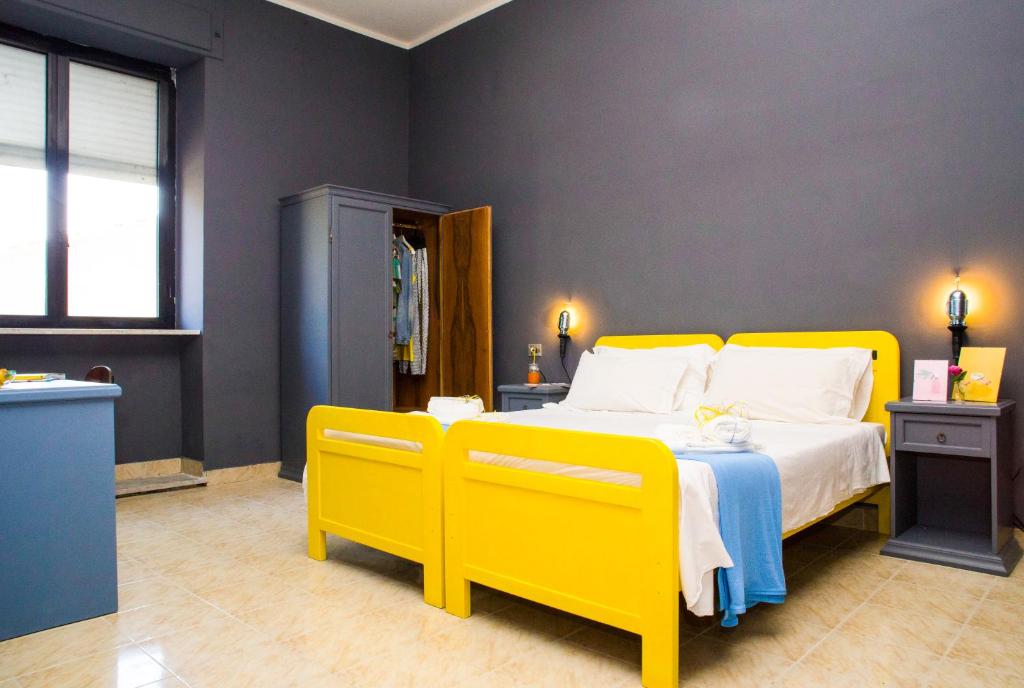 卡波迪蒙泰Lako Hostel的一间卧室配有黄色的床和两把椅子