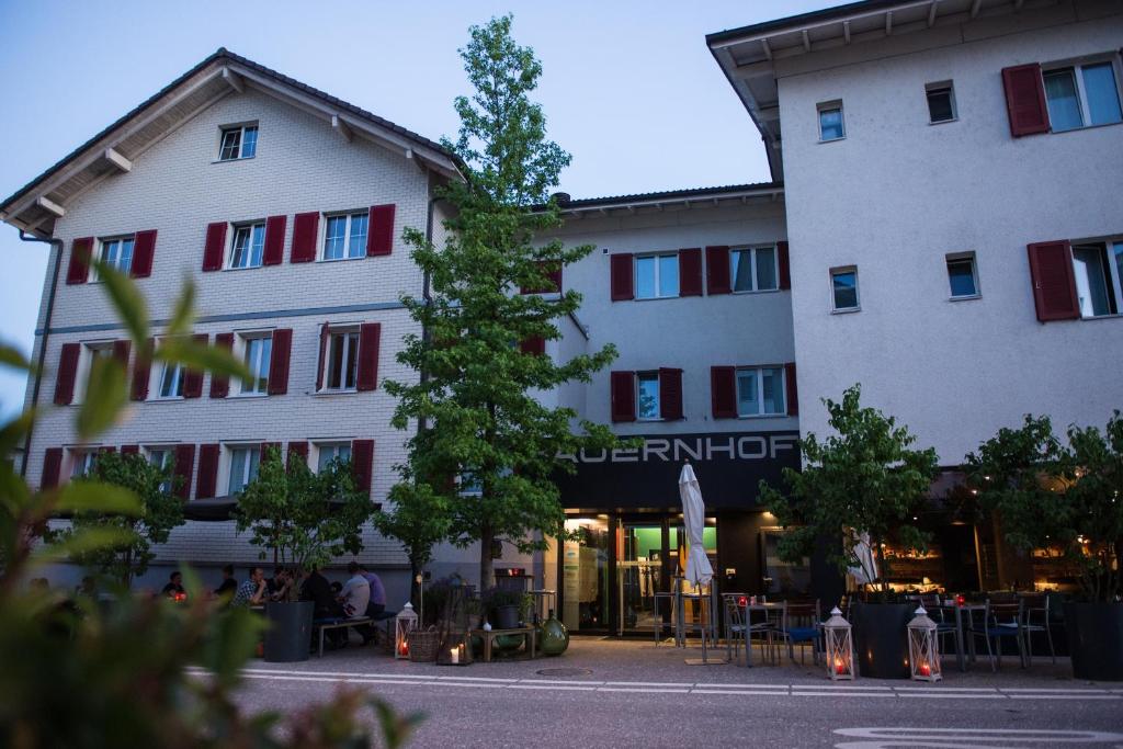 里施Hotel Bauernhof - Self Check-In Hotel的前面有棵树的建筑