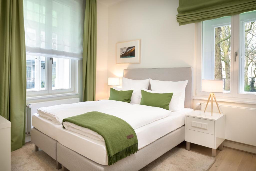 奥斯纳布吕克贝格曼奥斯纳布吕克寄宿旅馆的一间卧室配有一张绿色的大白色床。