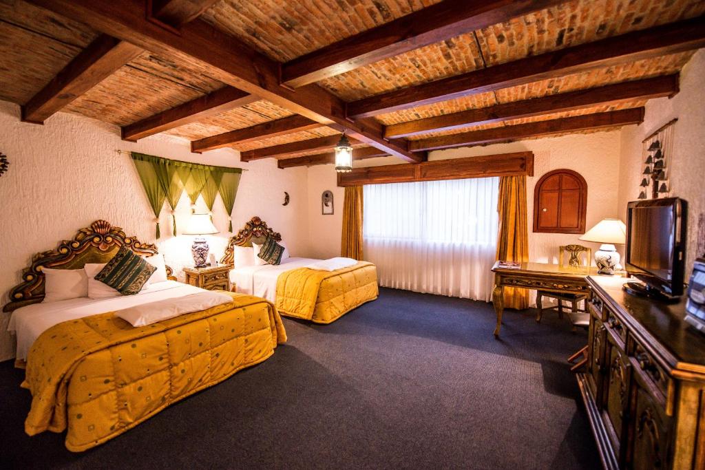 瓜达拉哈拉拉麦森德索酒店的酒店客房设有两张床和电视。