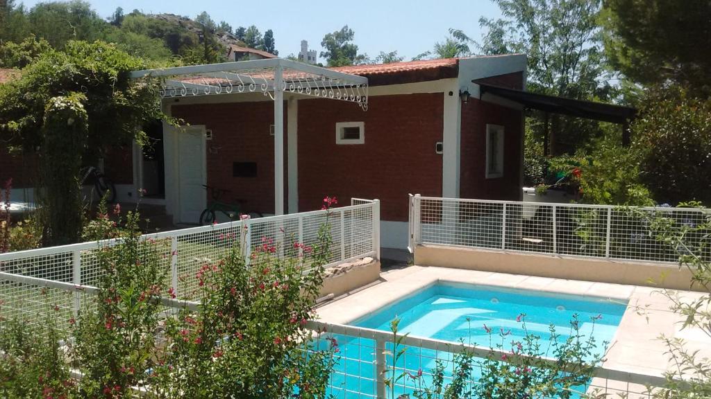 波特雷罗德洛斯弗内斯Cabañas Molinos de Vientos的一座环绕着房子的带围栏的游泳池