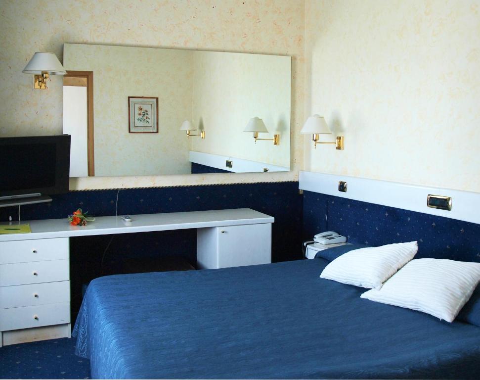 皮亚琴察欧洲酒店的一间卧室配有蓝色的床和大镜子