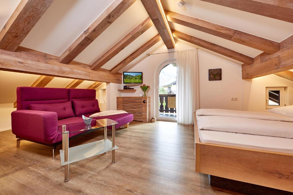 加尔米施-帕滕基兴Ferienwohnung Wittmann的一间卧室配有一张紫色的床和一张沙发