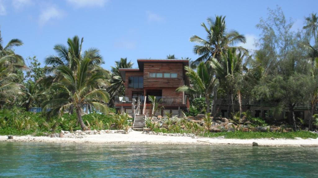 拉罗汤加Kaireva Beach House的棕榈树海滩上的房子