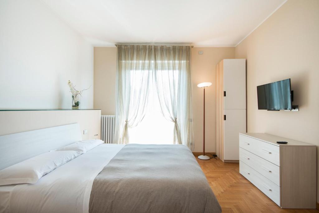 Villa Guardia卡萨福斯克罗公寓的卧室设有一张白色大床和一扇窗户。