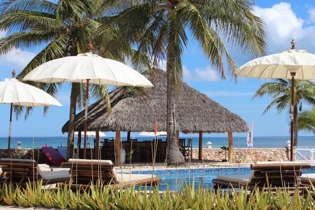 内布拉拉T-兰德度假酒店的一个带椅子和遮阳伞的游泳池以及棕榈树