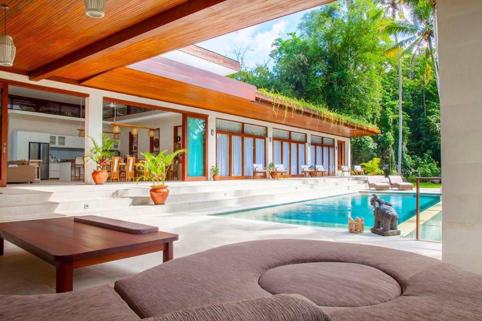 乌布Villa Merdu Ubud的一个带游泳池和房子的客厅