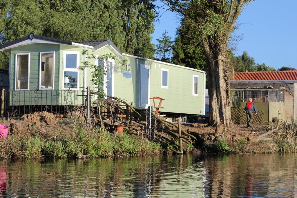 亨伯河畔巴顿Marshlands Lakeside Nature Retreat的水边的小房子