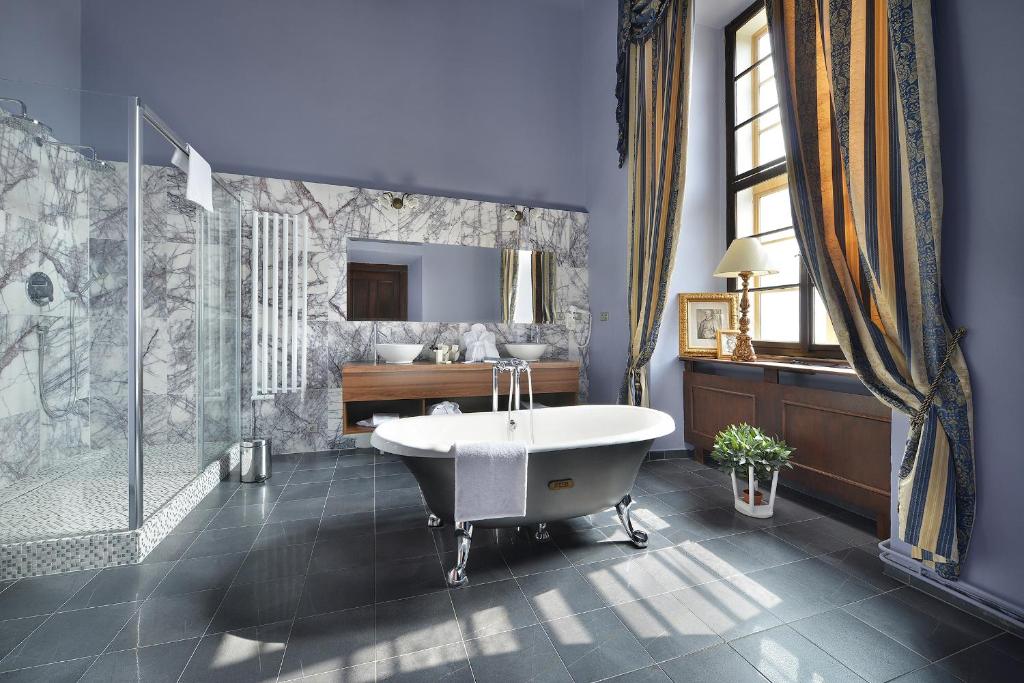 娄切尼卢森花园城堡酒店的带浴缸、淋浴和盥洗盆的浴室