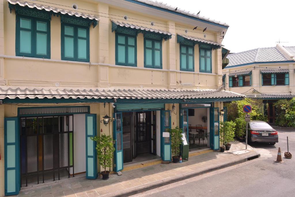曼谷内伯蒲通住宿加早餐旅馆的街道上的建筑物,前面有停车位
