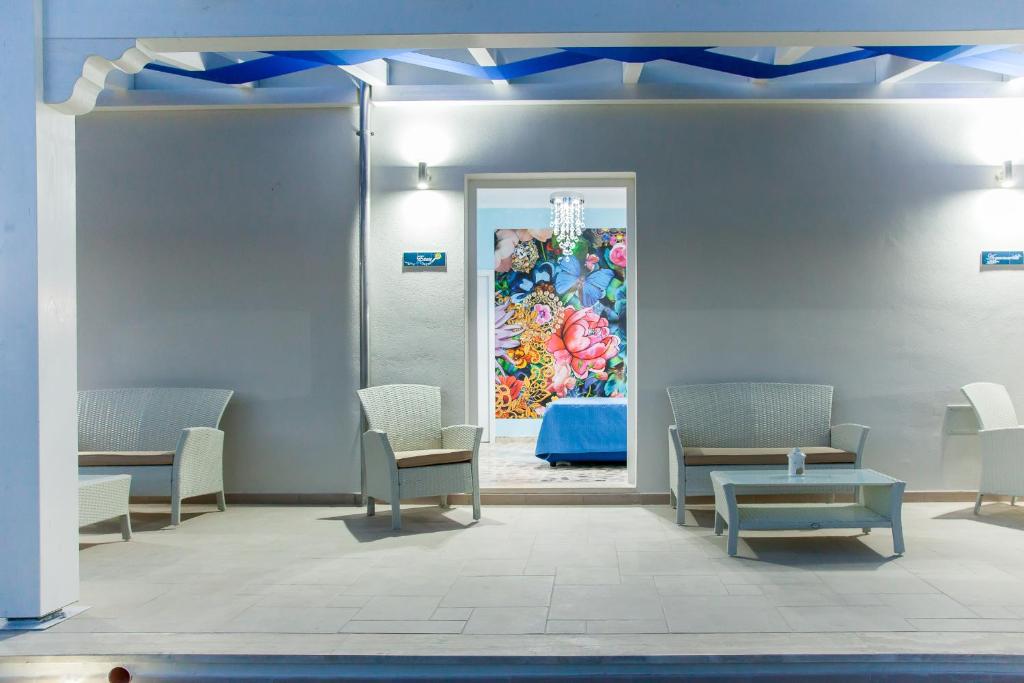 切萨雷奥港Blu d'aMare B&B的一间设有椅子和墙上一幅画的等候室