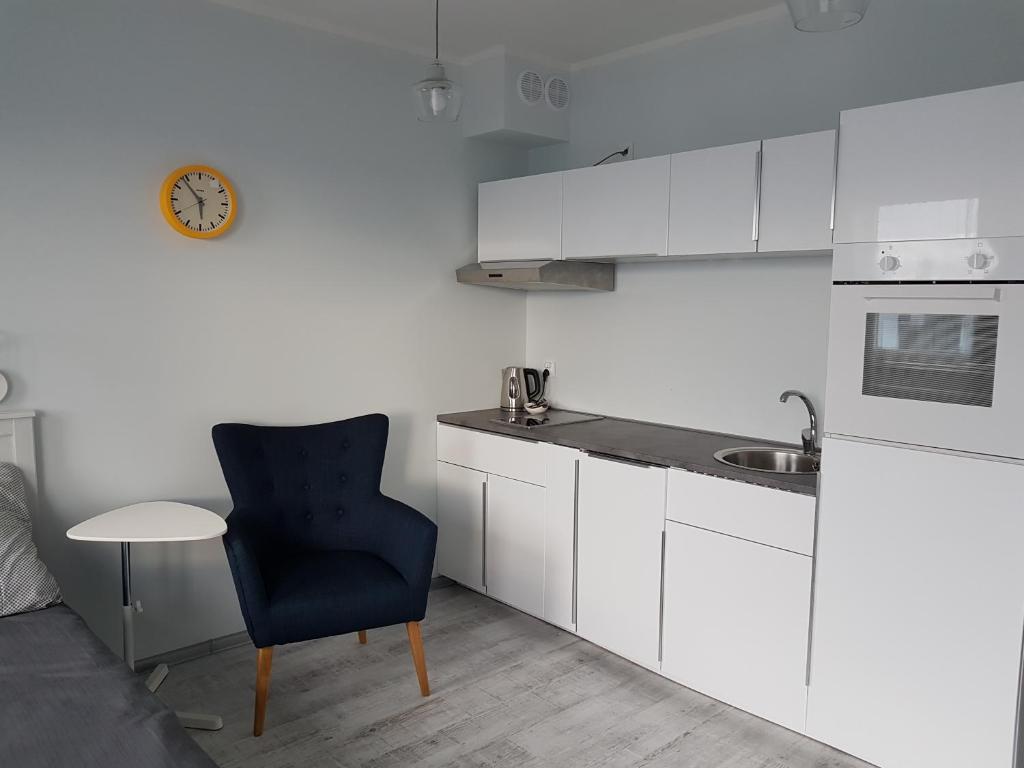 什切青Cukrownia的厨房配有蓝色椅子和水槽