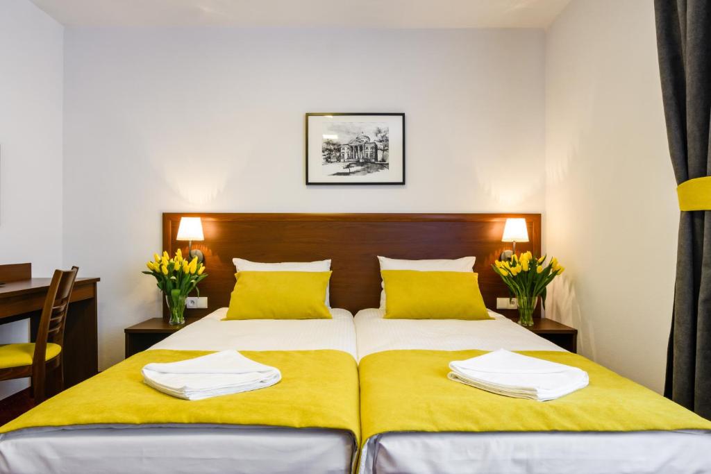 华沙L26 Łopuszańska的一间卧室配有一张带黄色床单和黄色枕头的床。