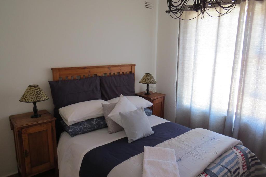 梅森堡Chamomile Cottage 2的卧室配有带白色枕头的大床