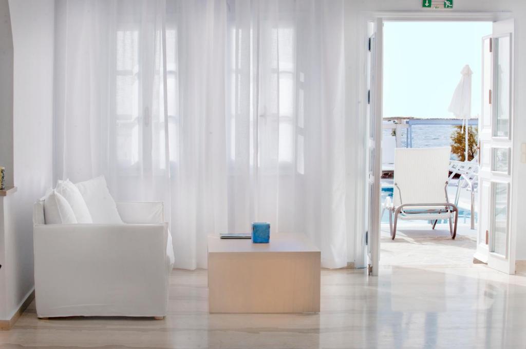 卡马利海神海滩酒店的客厅配有白色家具和桌子
