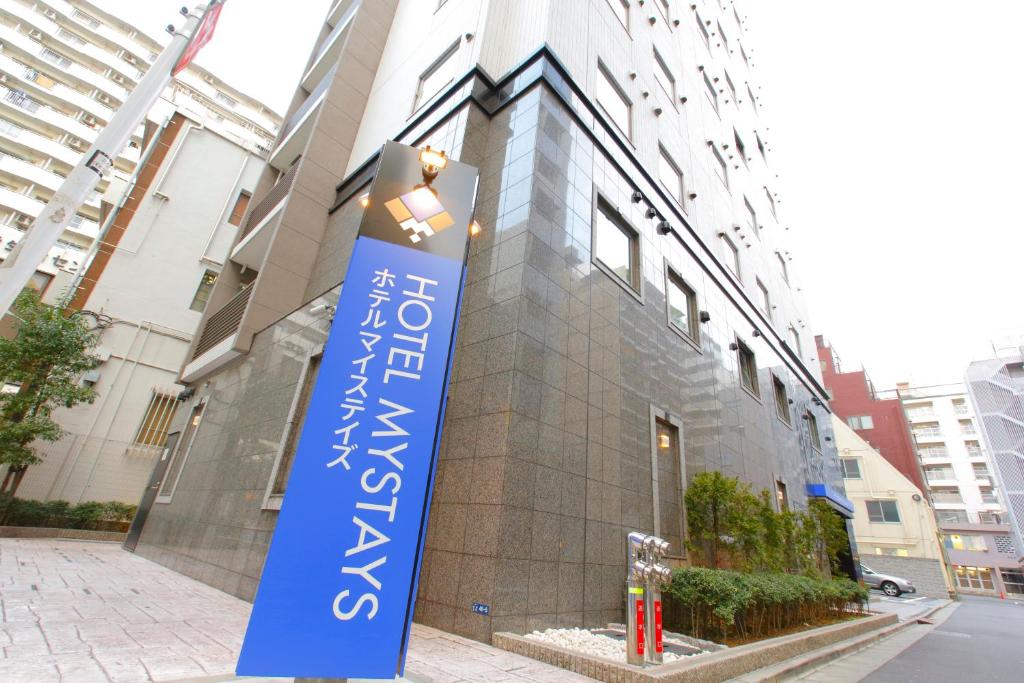 东京MYSTAYS 蒲田酒店的建筑前的蓝色标志