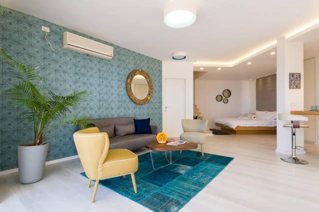 海法Eshkol Housing Haifa - Wallenberg Suites Complex的带沙发的客厅和卧室