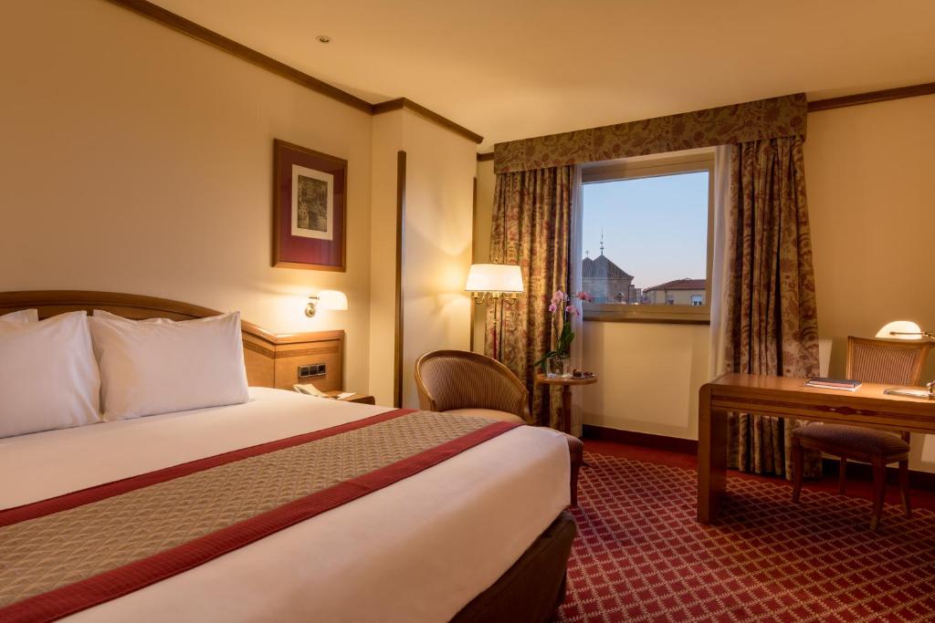 萨拉曼卡梅里亚拉斯克拉拉斯精品酒店的配有一张床、一张书桌和一扇窗户的酒店客房