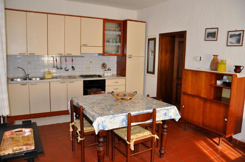 蓬塔阿拉Appartamenti Podere 270的厨房配有桌子、椅子和桌子,厨房