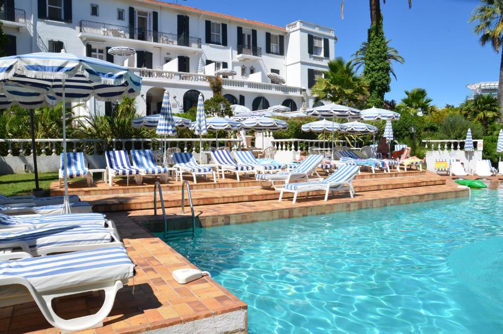 胡安莱潘德米莫萨酒店的一个带蓝色和白色椅子及遮阳伞的游泳池