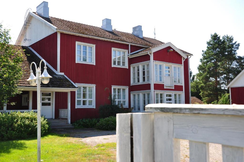 NorinkyläOpintola Bed & Breakfast的红色的房子,设有白色的窗户和栅栏
