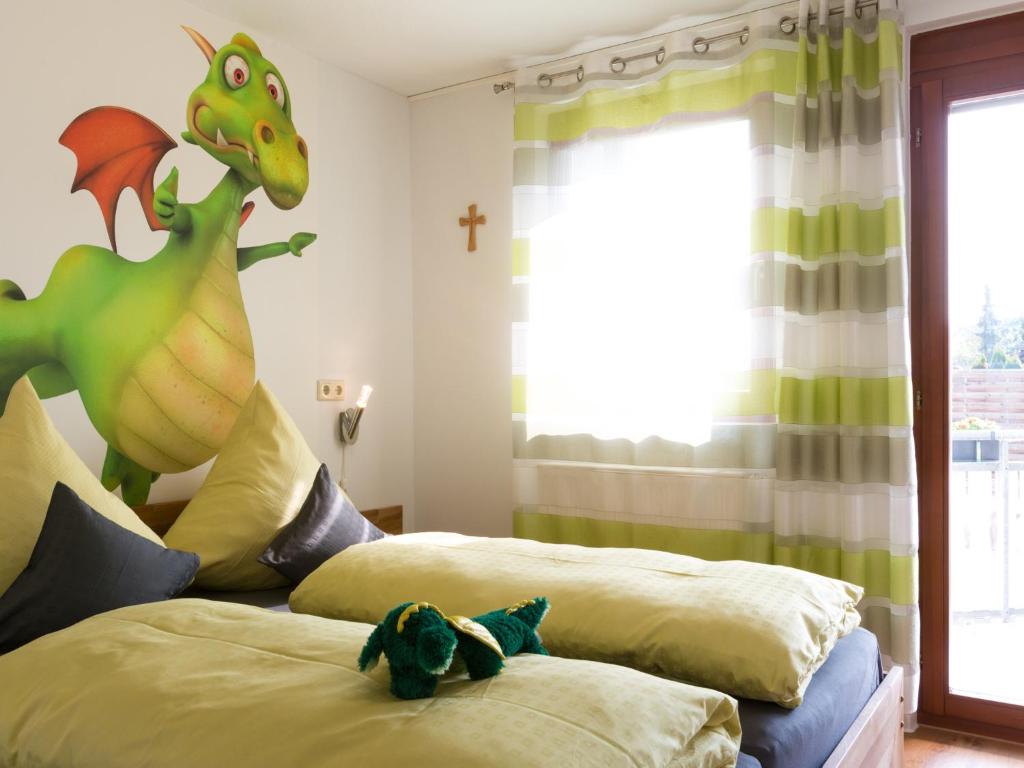 鲁斯特Ruster Drachennest的一间卧室配有两张床,里面装有玩具恐龙