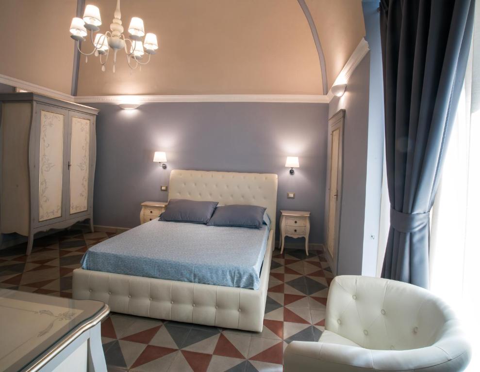 加拉托内帕拉佐柏夫住宿加早餐旅馆的卧室配有白色的床和椅子