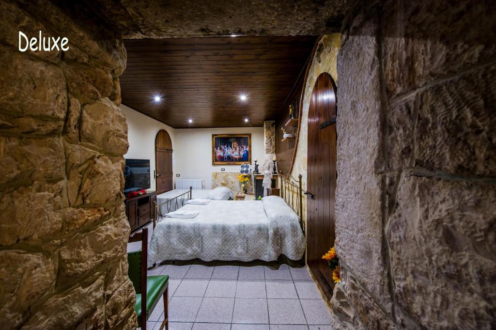 马丁纳弗兰卡La Cutizza B&B的卧室配有一张石墙内的大床