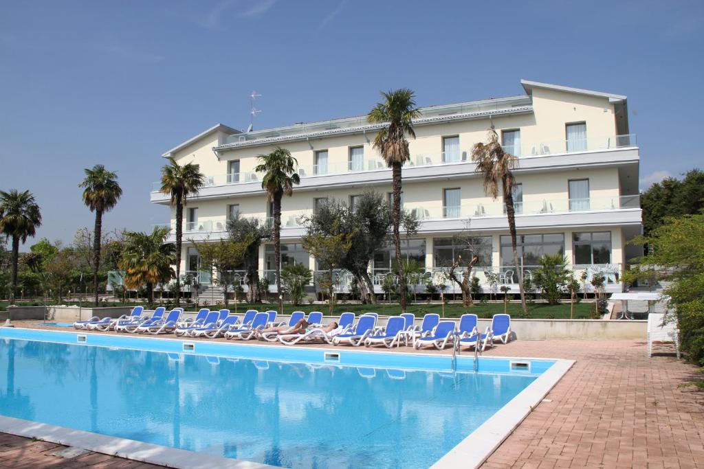 莫尼加Front Lake Hotel Villa Paradiso Suite的一个带椅子和游泳池的酒店